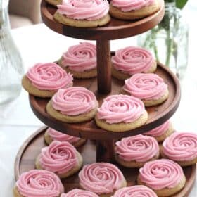 Rosette sugar cookies on a three tier wooden cookie stand.