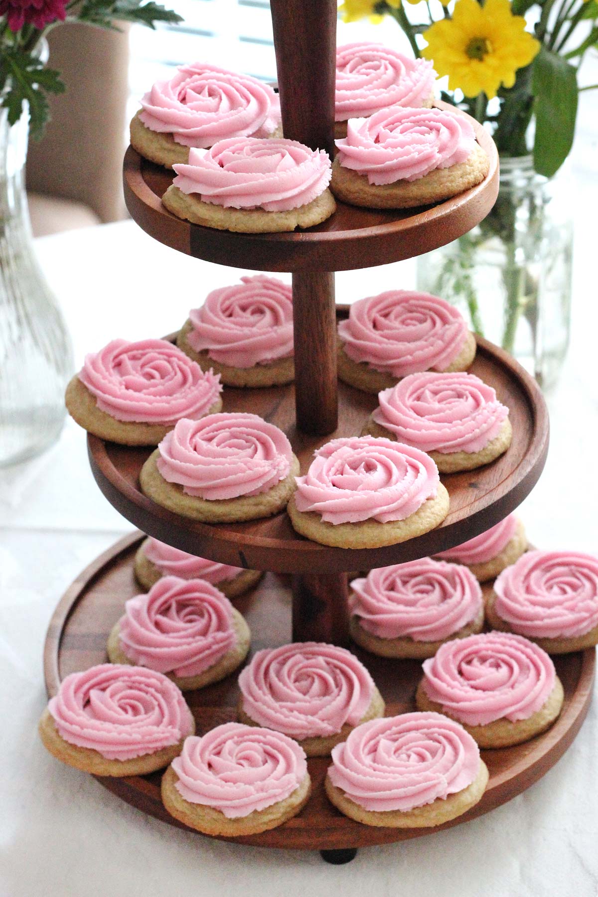 Rosette sugar cookies on a three tier wooden cookie stand.