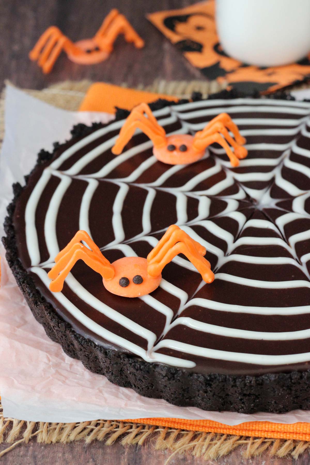 Close up of a spiderweb chocolate tart with two candy spiders on top.