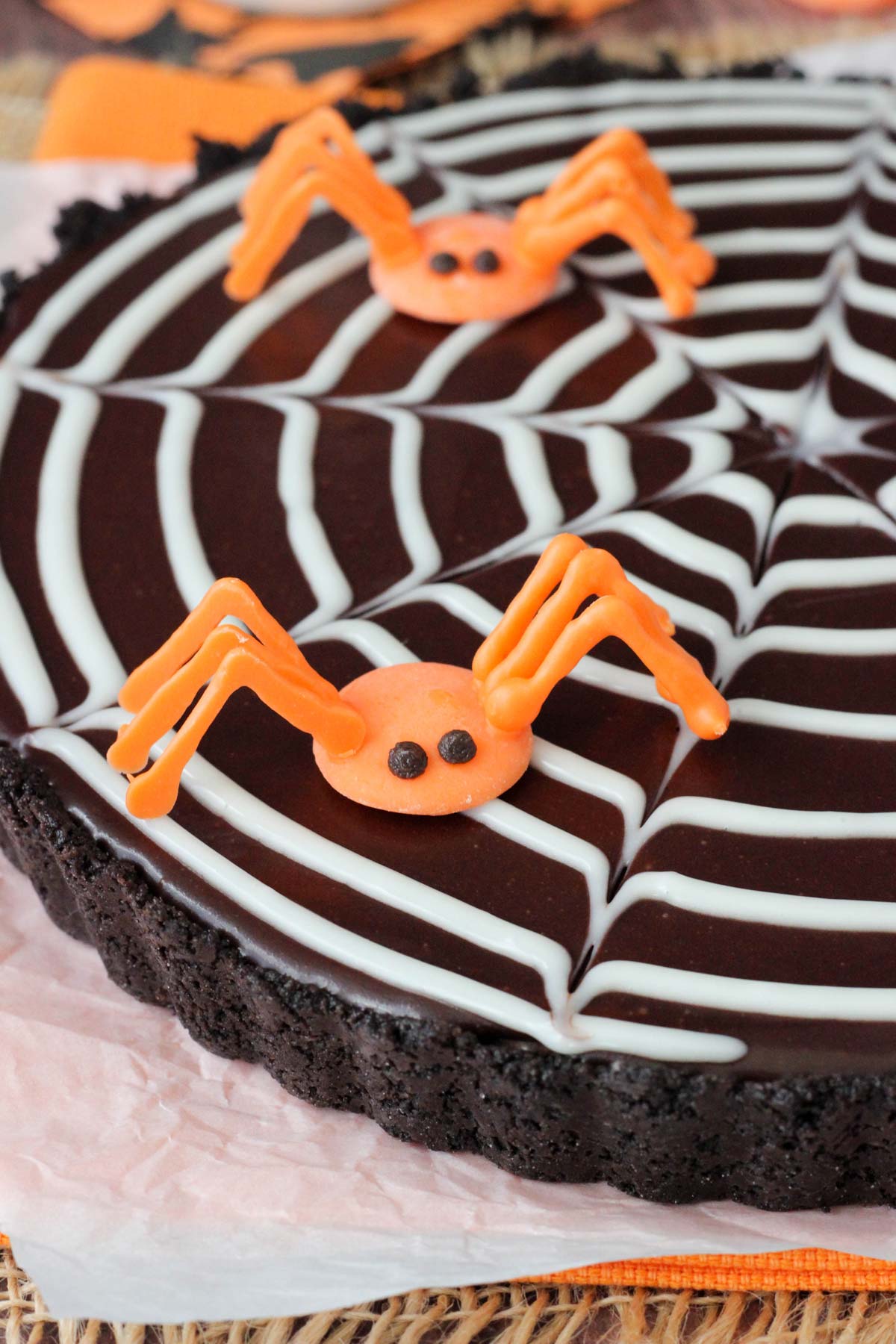 Close up of a spiderweb chocolate tart with two candy spiders on top.