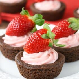 Close up of strawberry cheesecake chocolate cookie cups on a white plate.