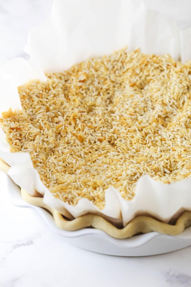 Rice on parchment paper in a pie crust for blind baking