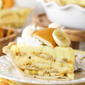 Side view of a slice of banana pudding pie on a white plate