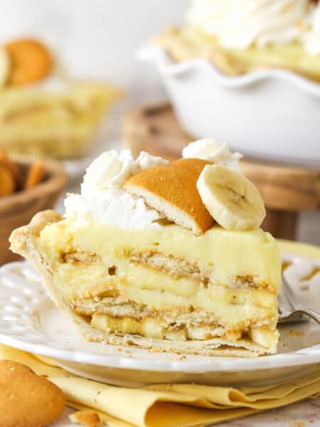 Side view of a slice of banana pudding pie on a white plate