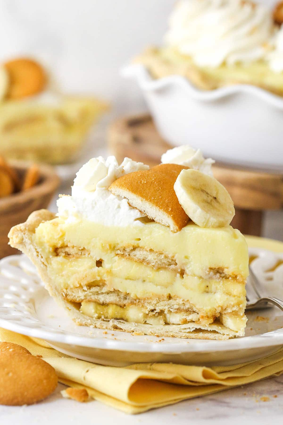 Side view of a slice of banana pudding pie on a white plate