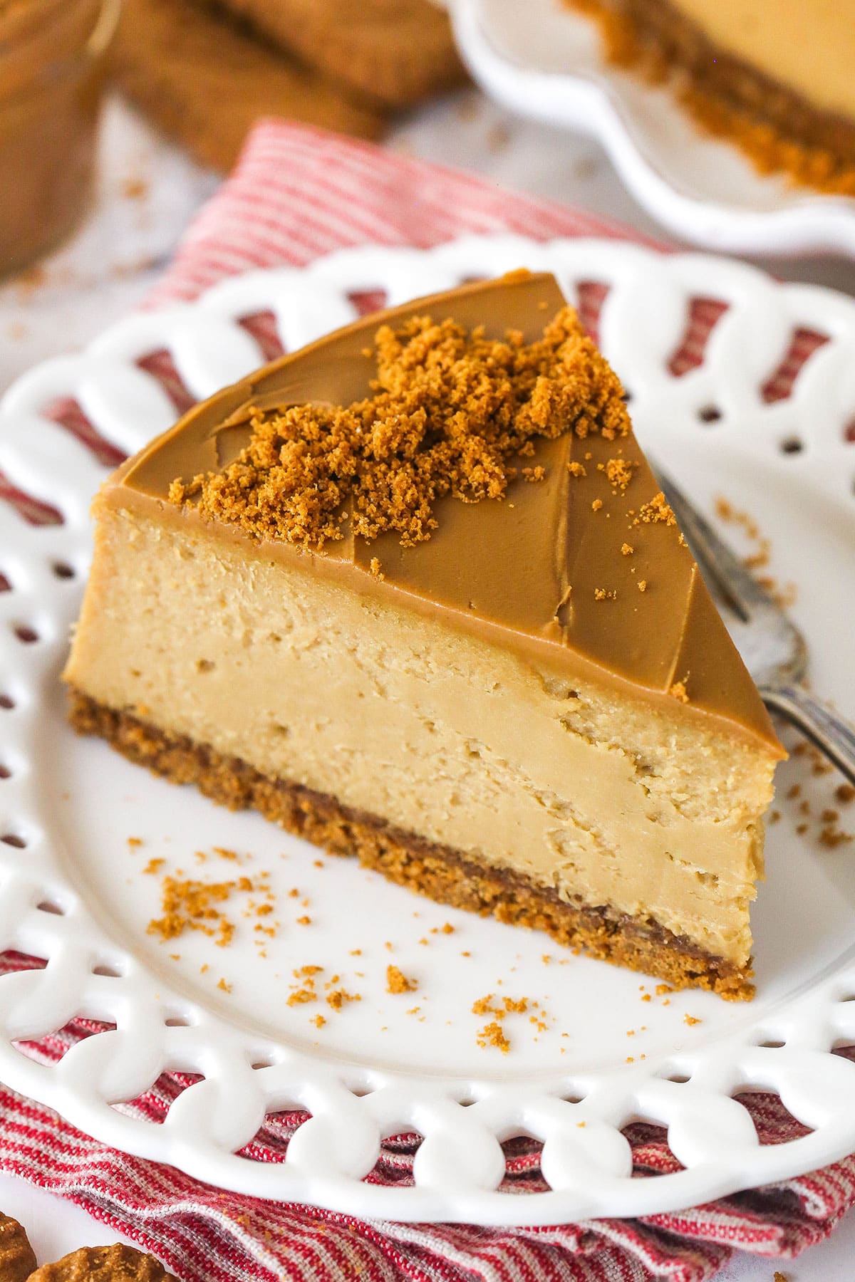 Overhead view of a slice of Biscoff cheesecake on a white plate