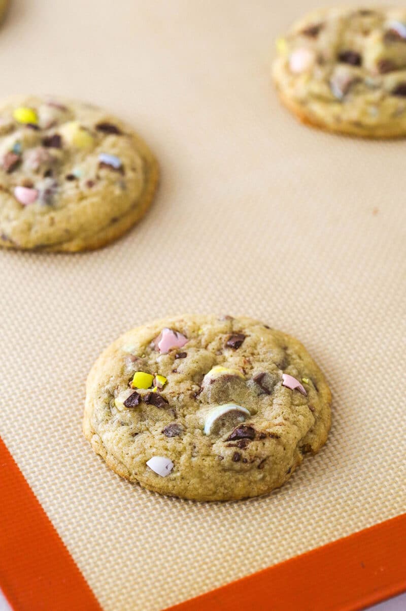 Every bite of these soft and chewy Cadbury egg cookies is dotted with crushed Cadbury eggs and chocolate. Perfect for spring & Easter! Freshly baked Cadbury egg cookies on a baking sheet