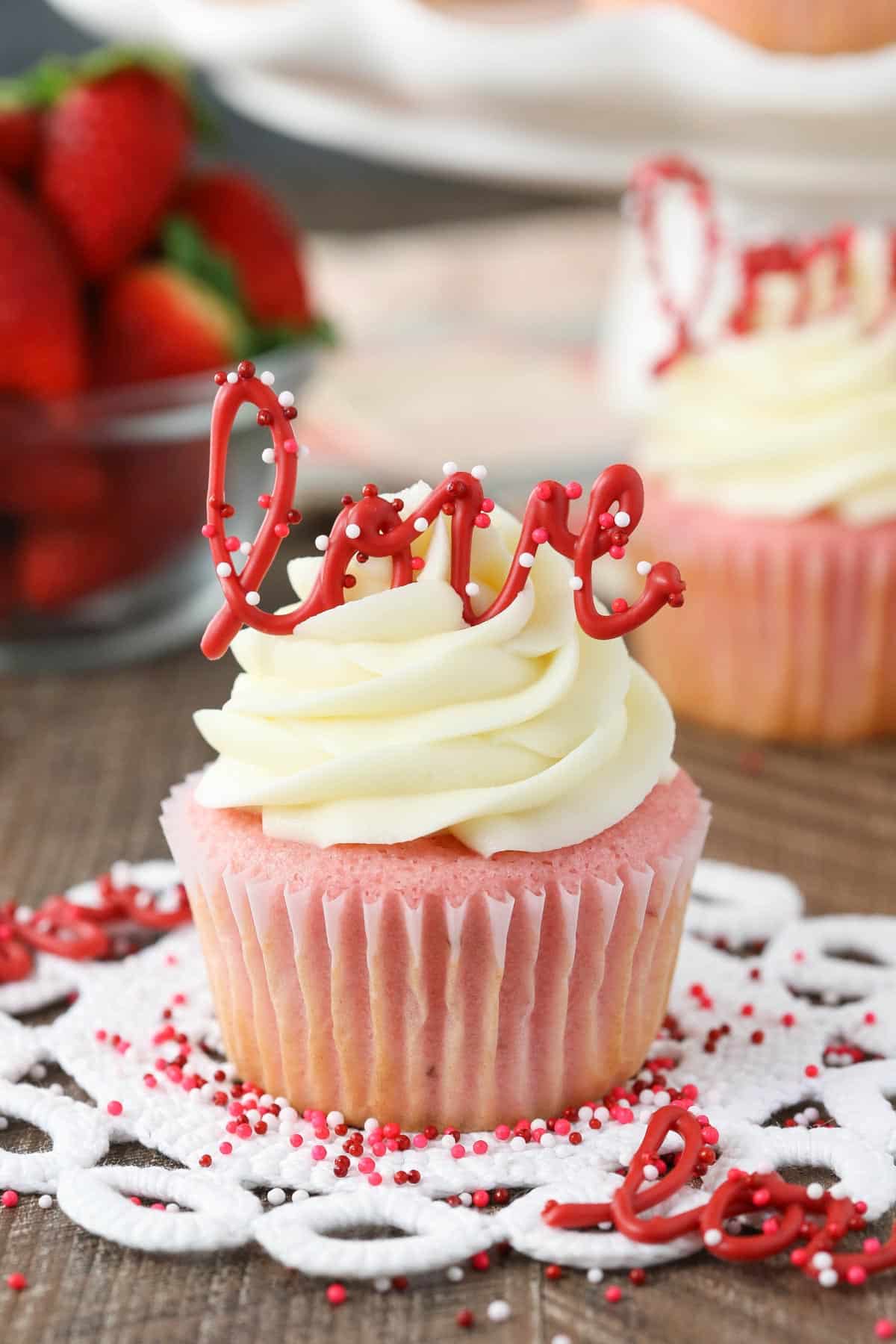Close up of a strawberry cupcake with cream cheese frosting.