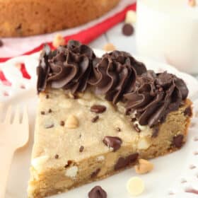 A slice of triple chocolate chip cookie cake on a white plate.