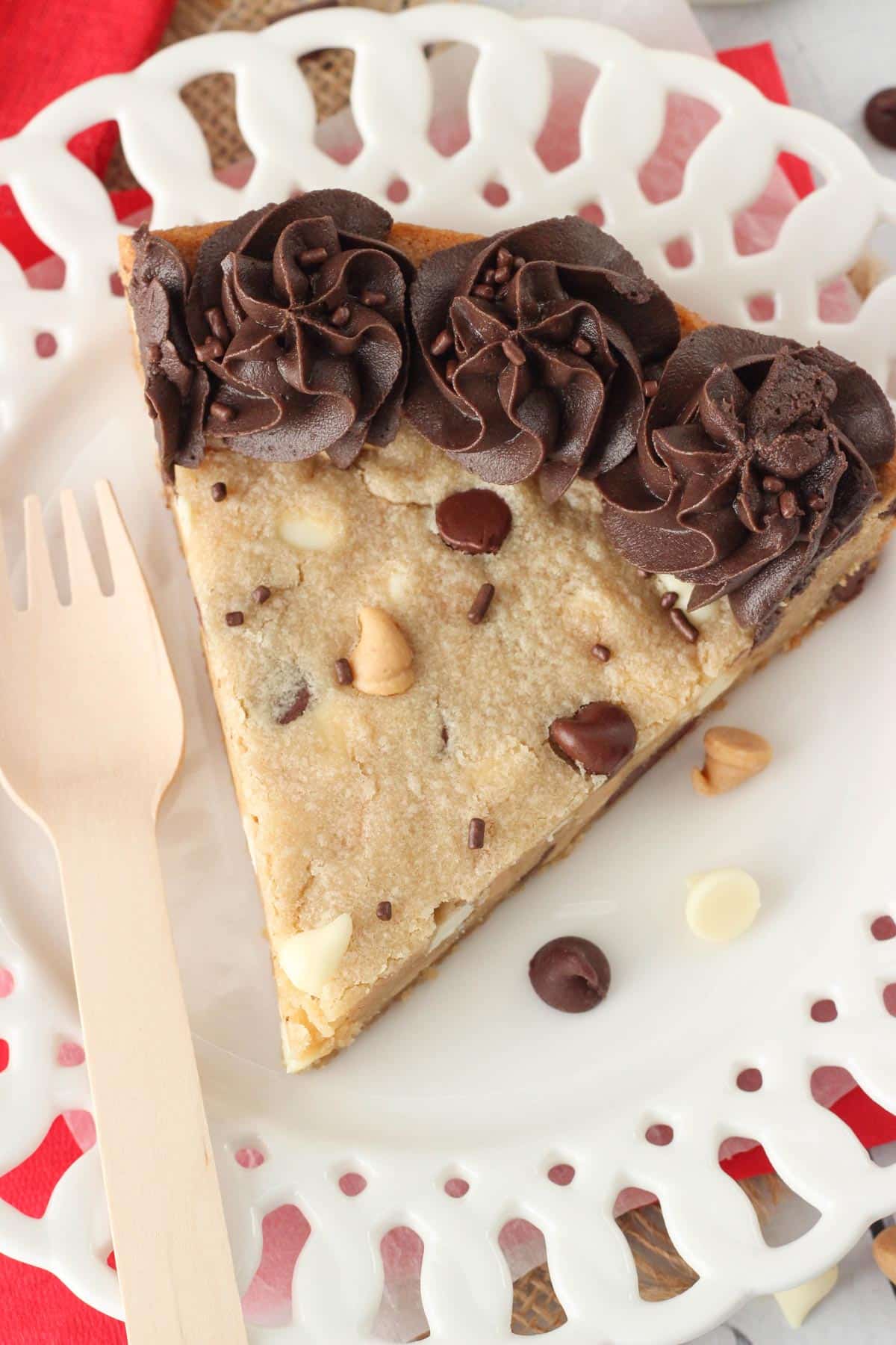 Top view of a slice of triple chocolate chip cookie cake on a white plate.