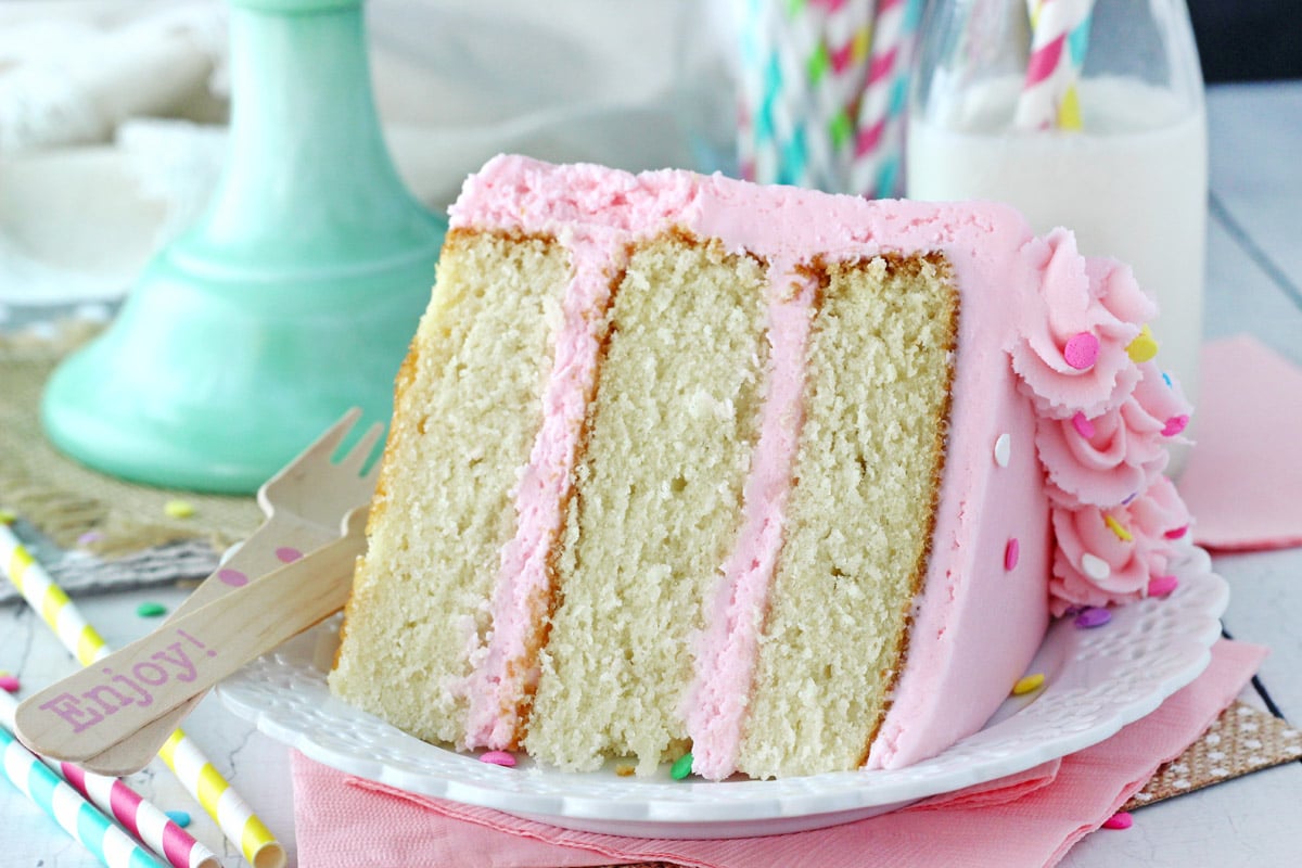 A slice of vanilla cake on a small white plate.