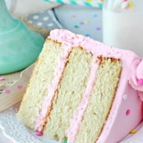 Close up of a slice of vanilla cake on a white plate.