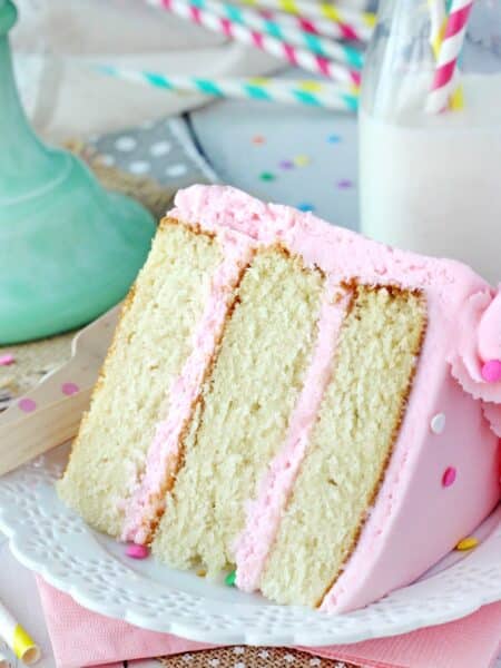 Close up of a slice of vanilla cake on a white plate.