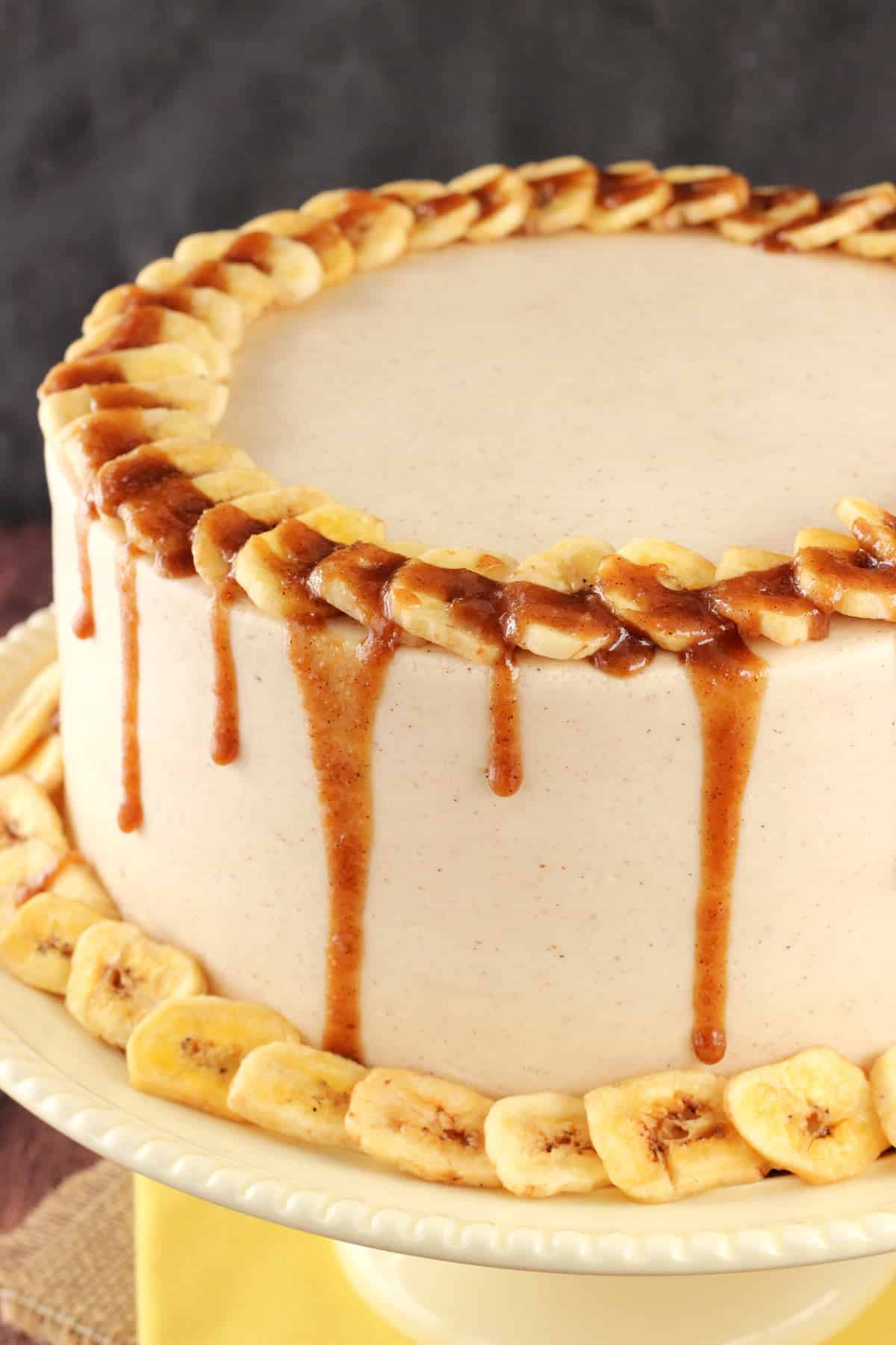 Close up of the top of a bananas foster layer cake drizzled with sauce.