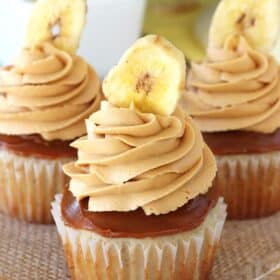 Three banoffee cupcakes on a piece of burlap.
