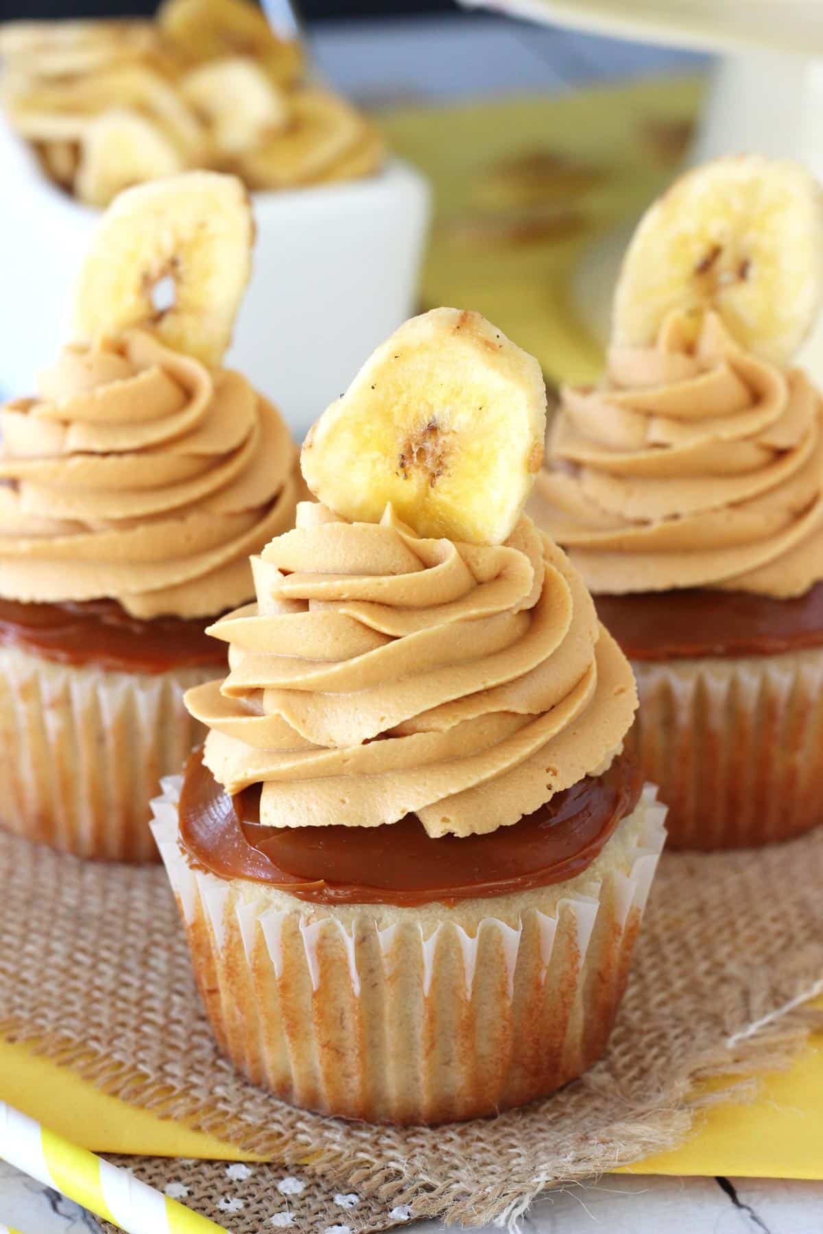 Three banoffee cupcakes on a piece of burlap.