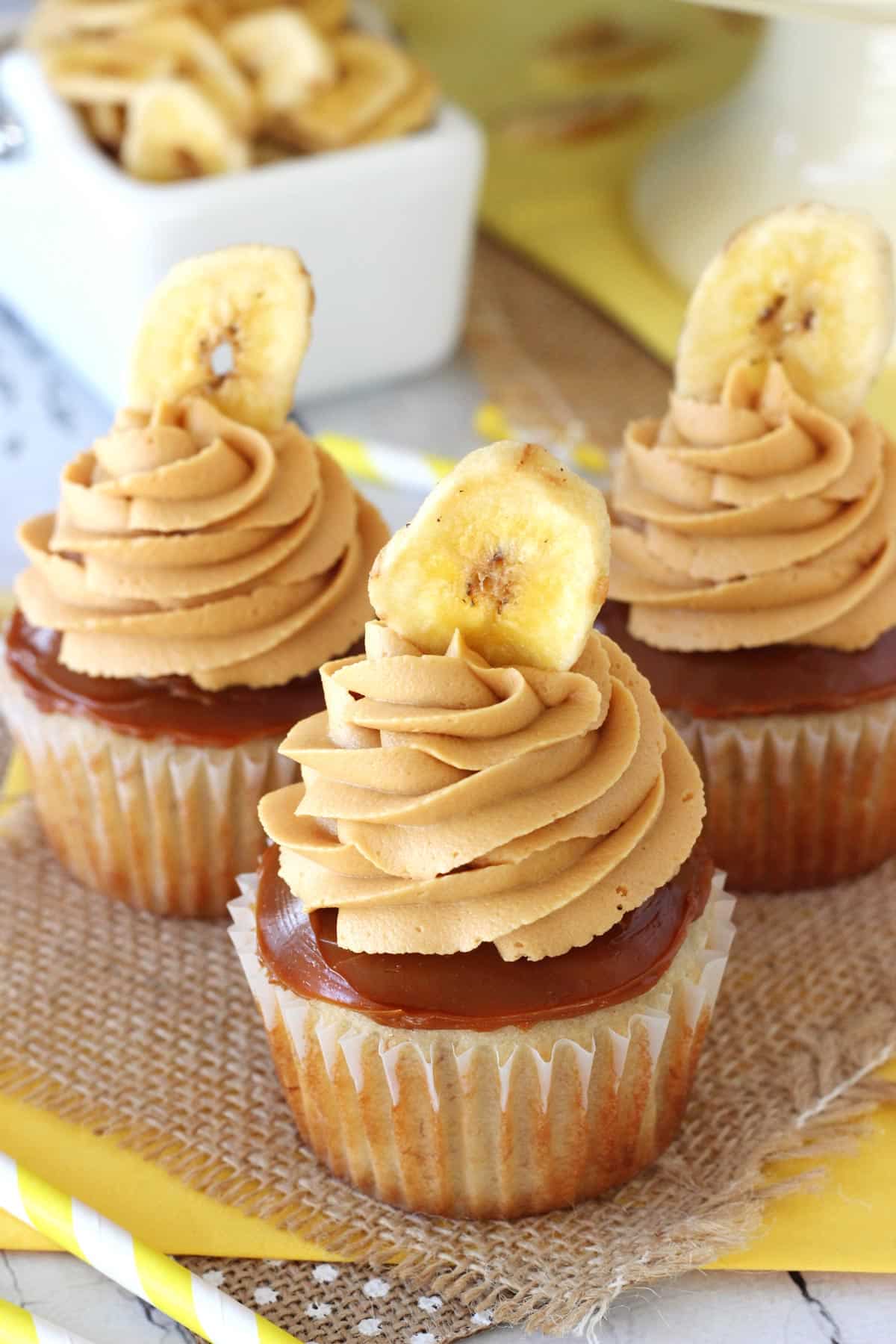 Three banoffee cupcakes on a piece of burlap.