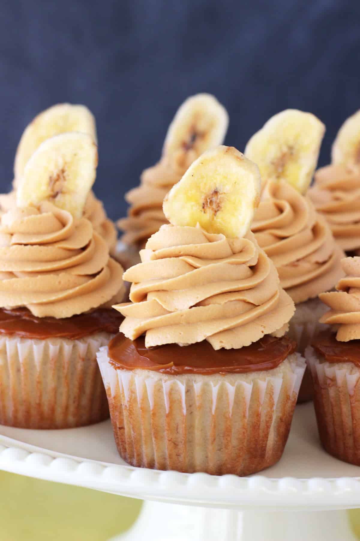 Close up of banoffee cupcakes on a white cake stand.