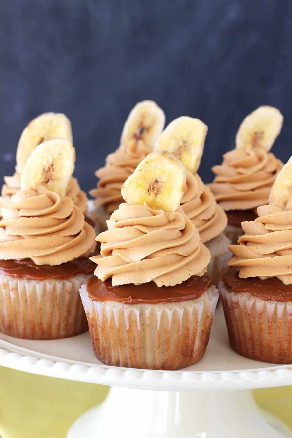 Close up of banoffee cupcakes on a white cake stand.