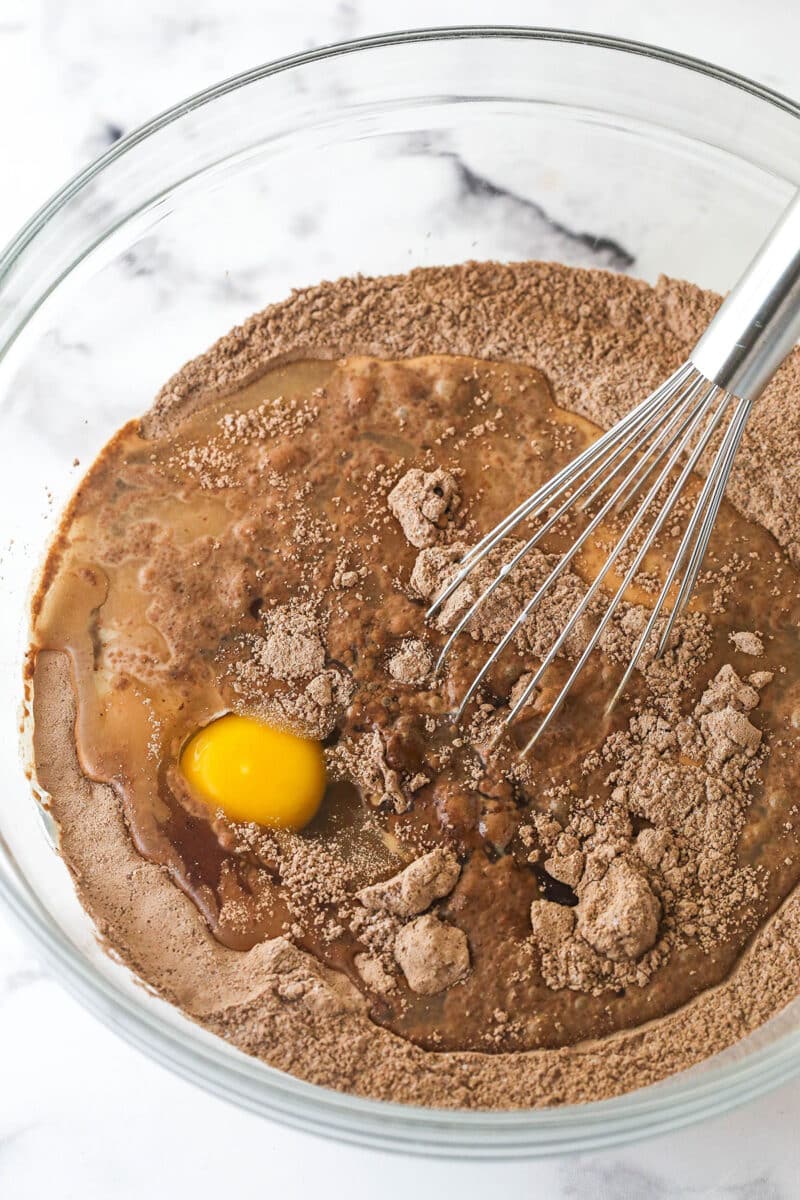 These Black Bottom Cupcakes combine two desserts in one with a rich chocolate cupcake and a creamy chocolate chip cheesecake filling. Whisking egg into dry cupcake ingredients