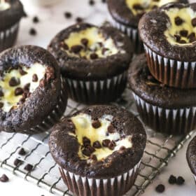 Black bottom cupcakes stacked on a wire rack