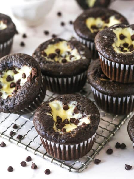 Black bottom cupcakes stacked on a wire rack