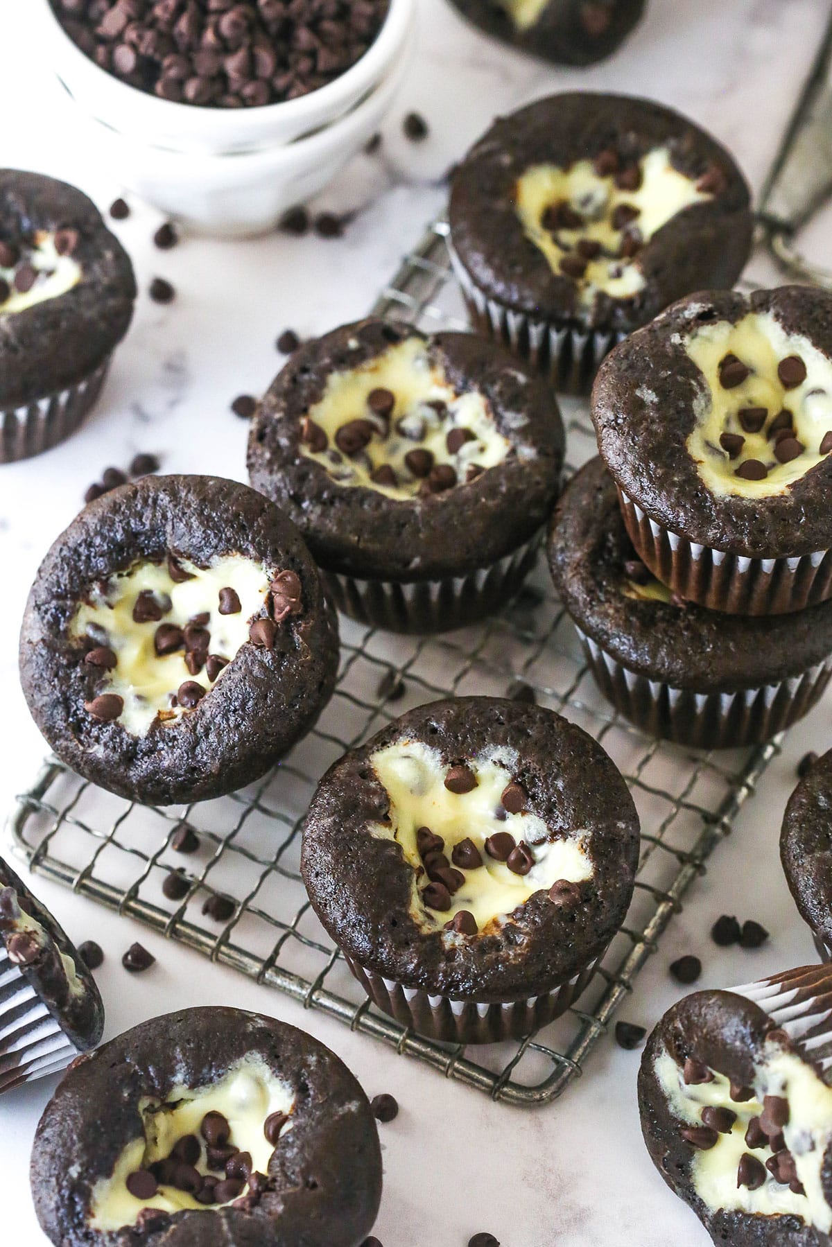 These Black Bottom Cupcakes combine two desserts in one with a rich chocolate cupcake and a creamy chocolate chip cheesecake filling. Overhead view of Black bottom cupcakes on a wire rack