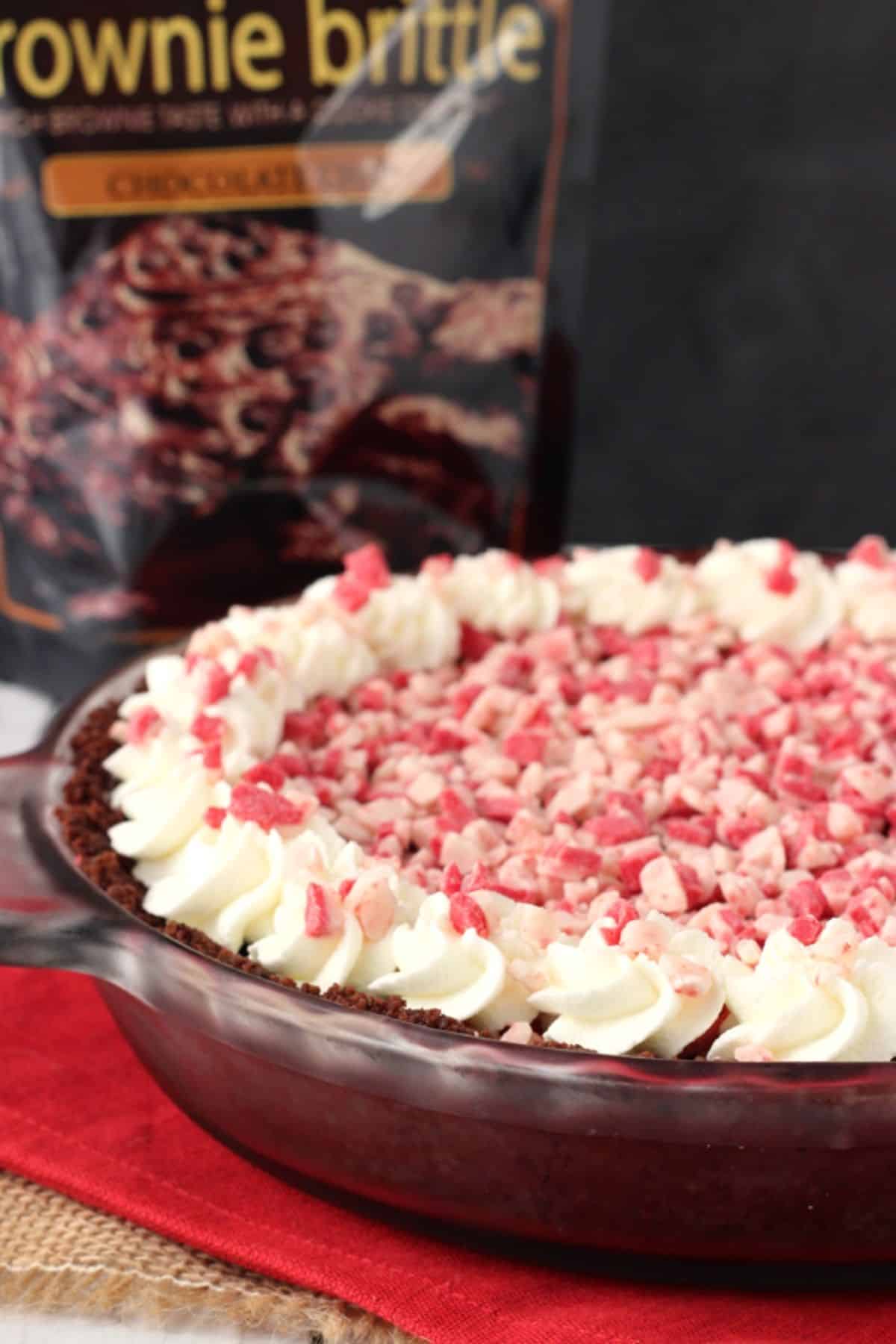 Close up of a Brownie Brittle peppermint chocolate pie with a bag of brittle in the background.