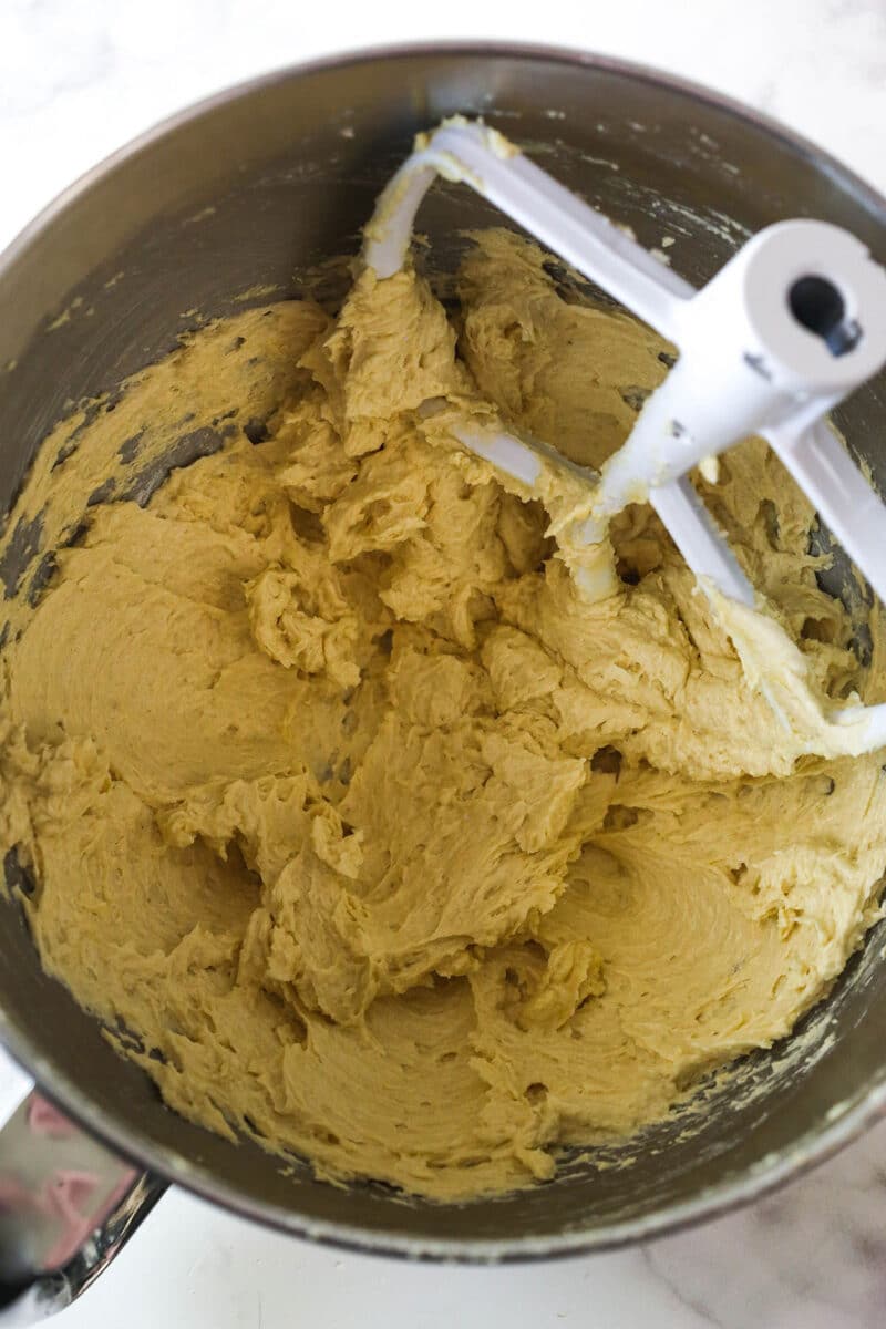 These Caramel Cookie Bars combine gooey caramel and chewy chocolate chip cookies in one perfect dessert. Easy to make! Wet cookie dough ingredients in a bowl