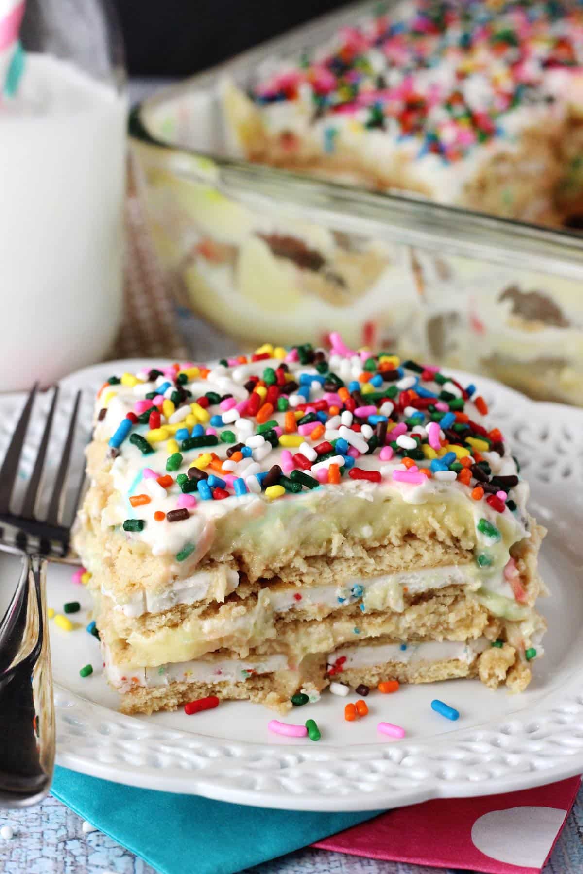 Close up of a slice of Funfetti birthday cake icebox cake on a small white plate.