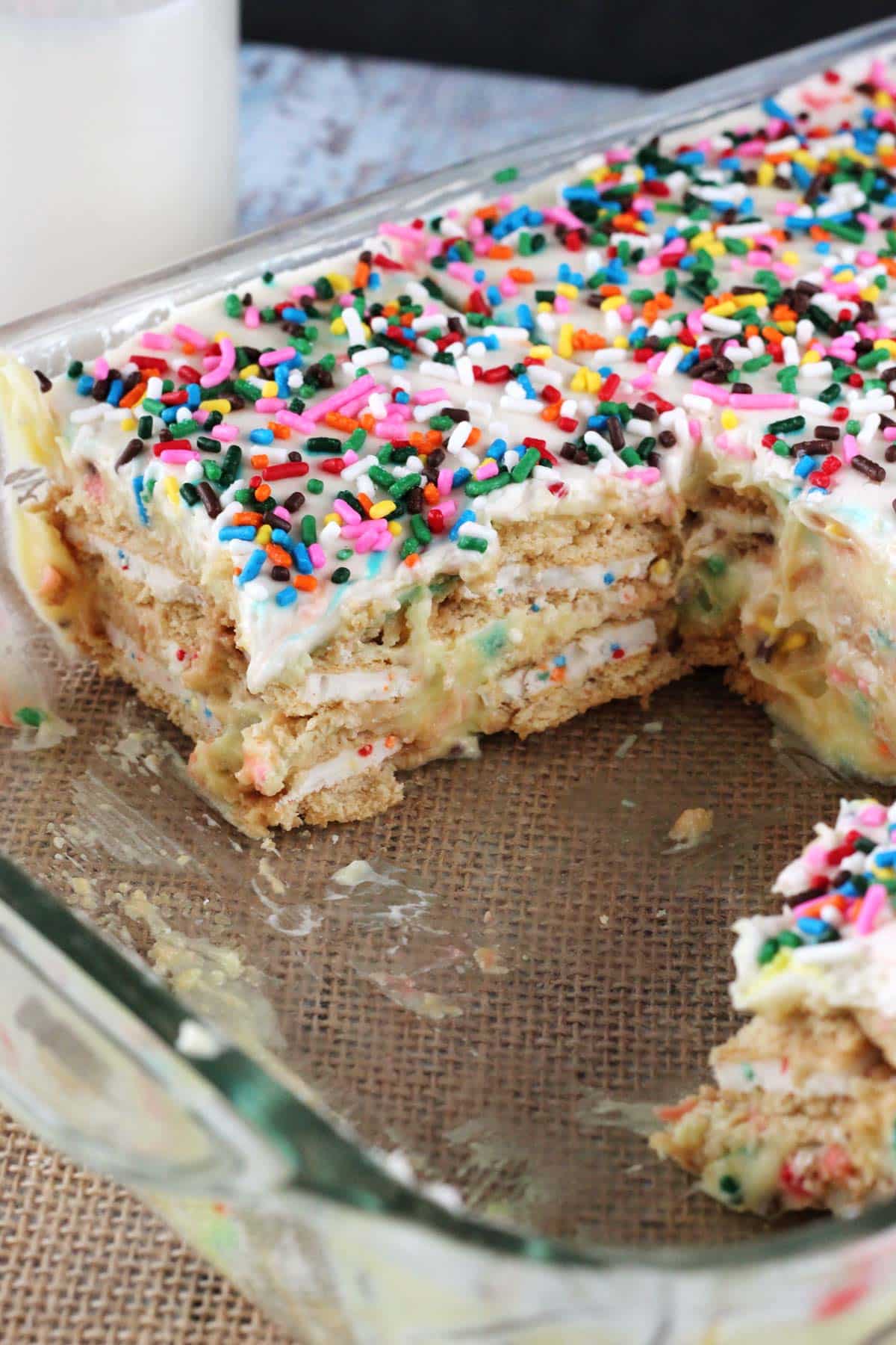 Funfetti birthday cake icebox cake in a baking pan with several slices removed to show layers.