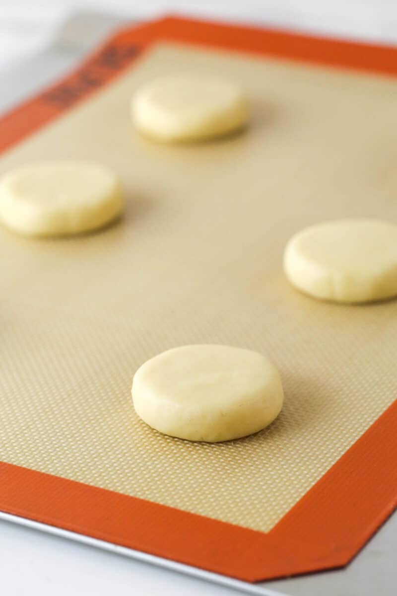 These copycat Lofthouse Cookies are soft and cakey with a melt-in-your-mouth texture and light flavor, just like the ones at the supermarket. Sugar cookie dough pressed into circles on a baking sheet