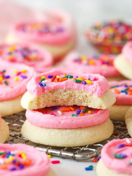 Two copycat Lofthouse cookies stacked on a wire rack, one with a bite missing