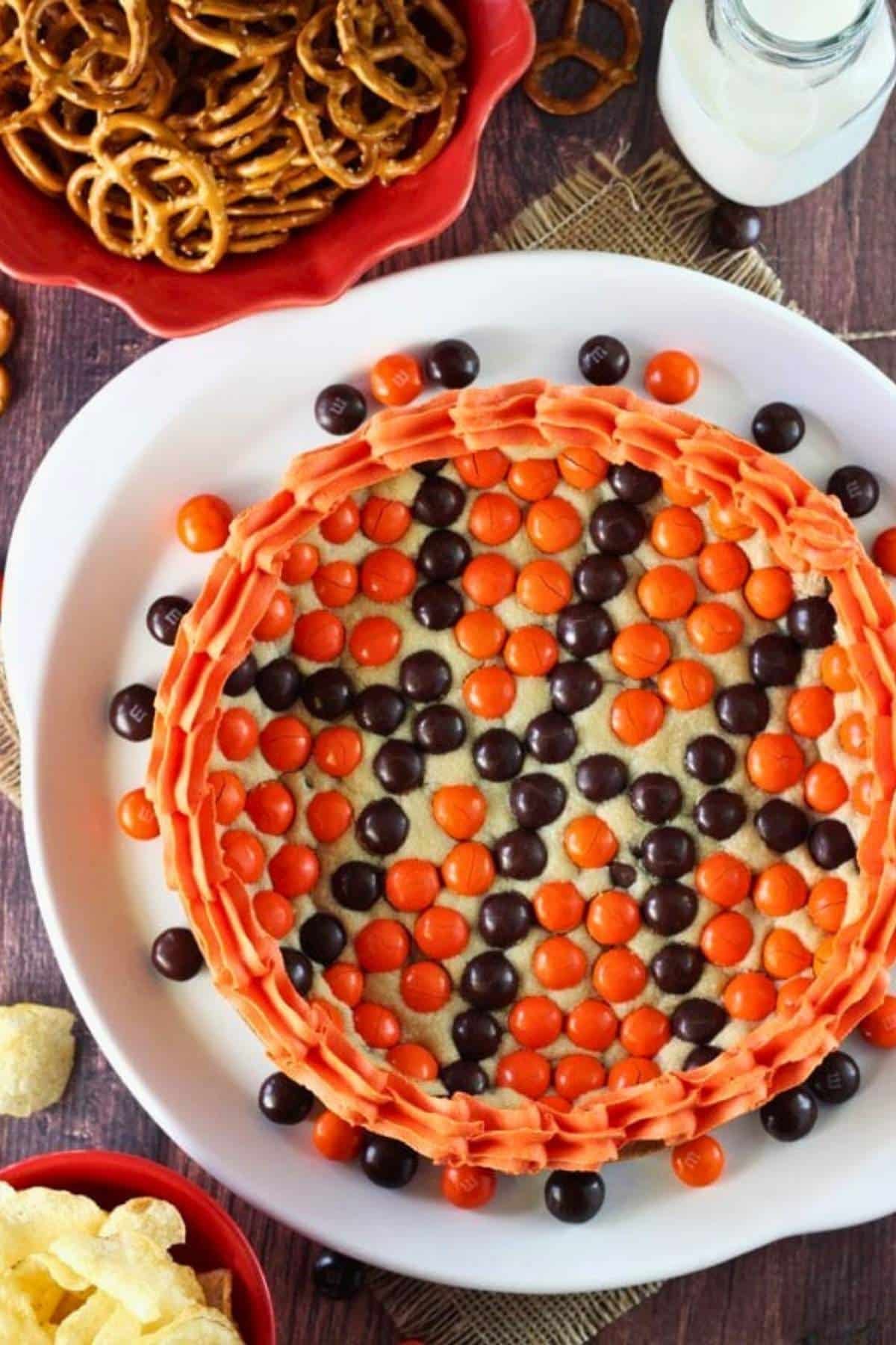 Top view of an M&M basketball cake on a white platter.