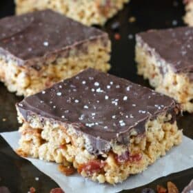 Close up of maple bacon rice krispie treats on a dark counter top.
