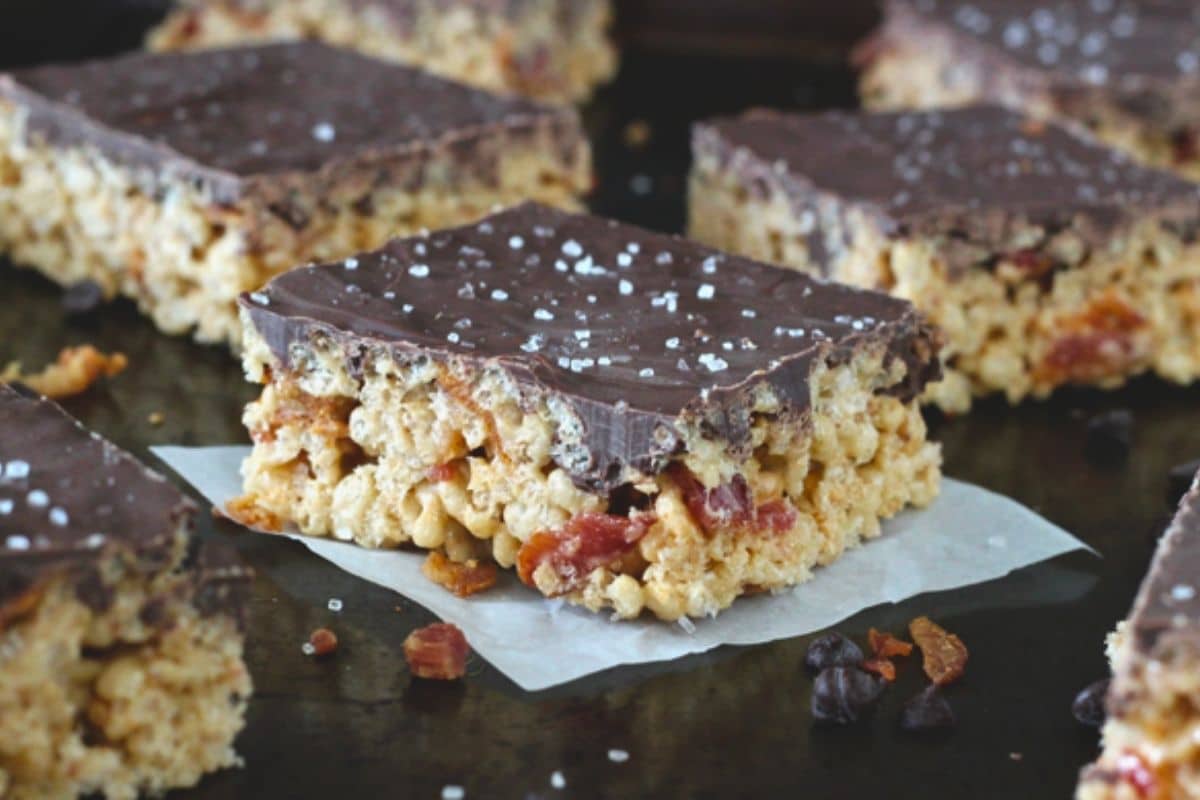 Close up of maple bacon rice krispie treats on a dark counter top.