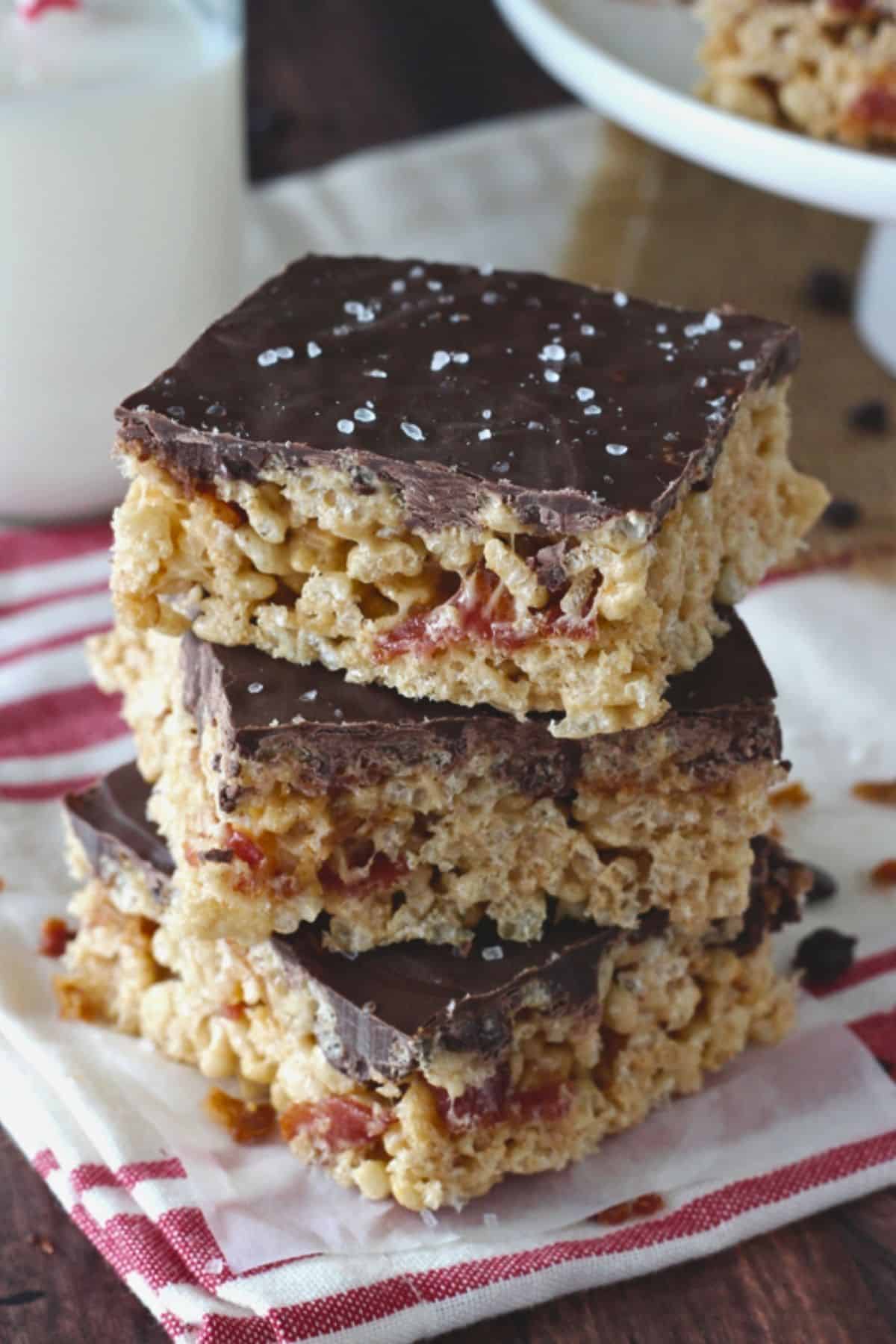 Side view of three maple bacon rice krispie treats stacked one on top of the other.