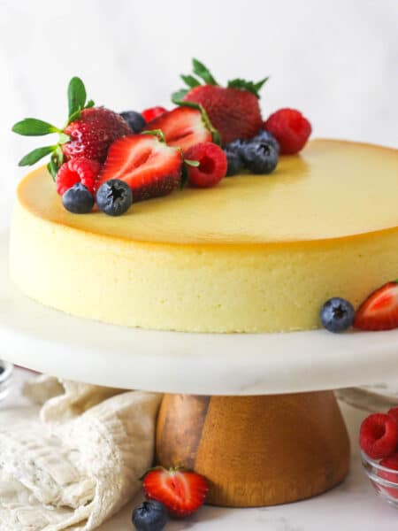 Ricotta cheesecake on a serving platter topped with fresh fruit
