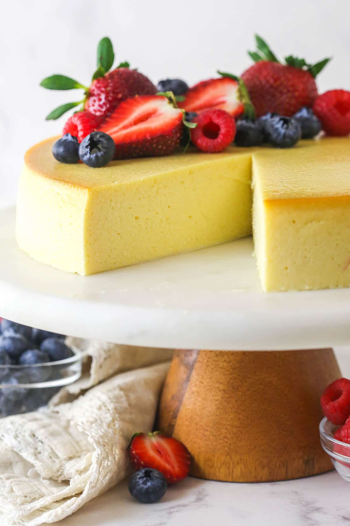 Ricotta cheesecake on a cake stand with one slice missing