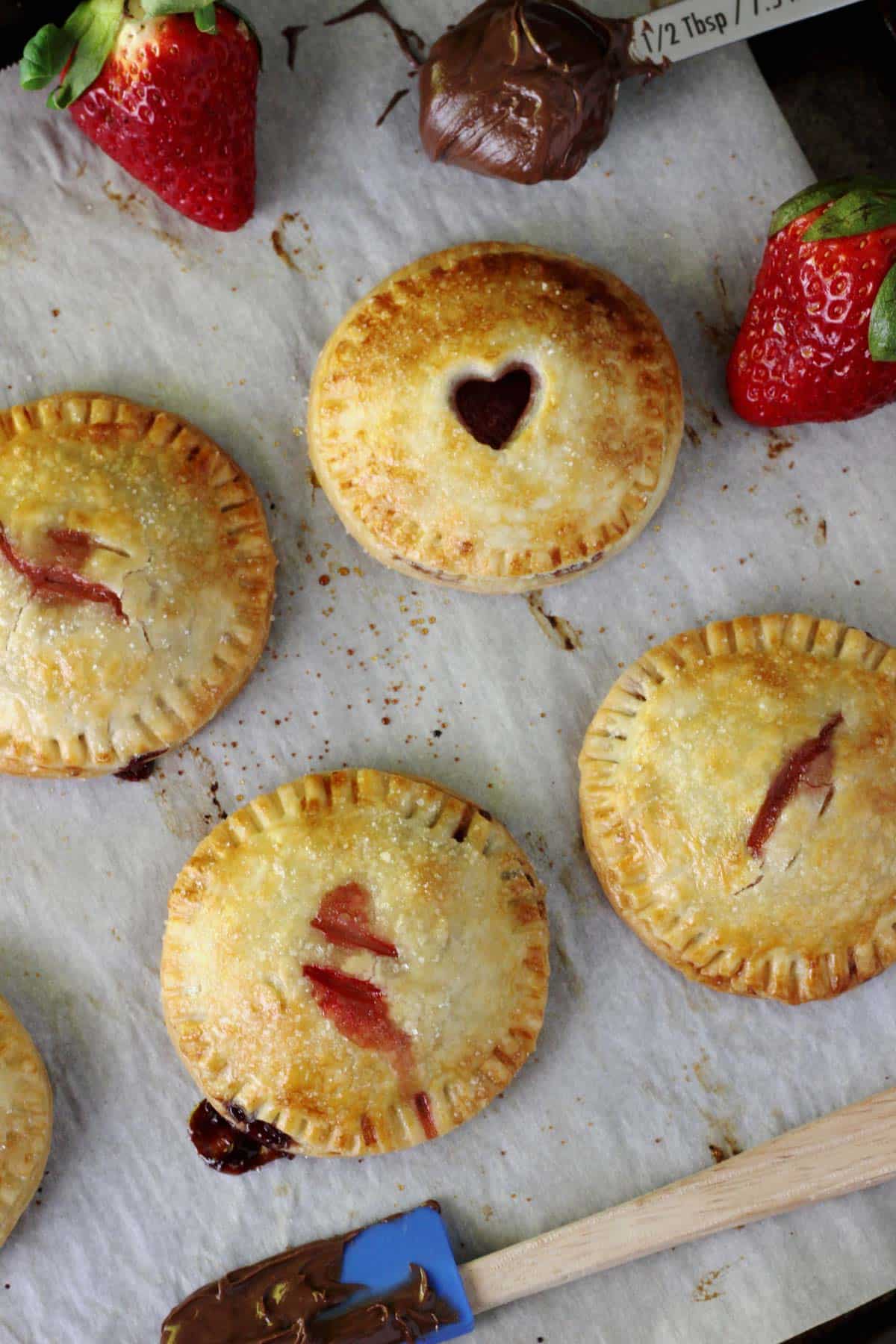 Overhead view of strawberry Nutella hand pies on a piece of parchment.
