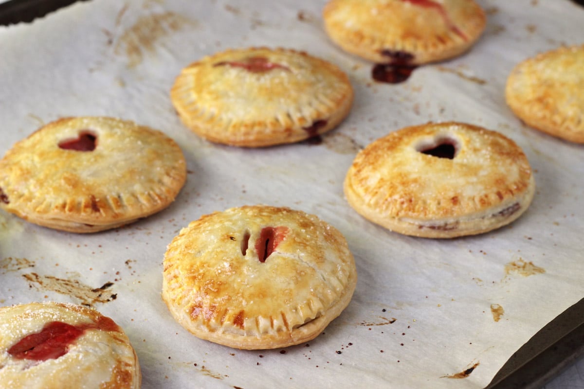 Baked strawberry Nutella hand pies on a piece of parchment.
