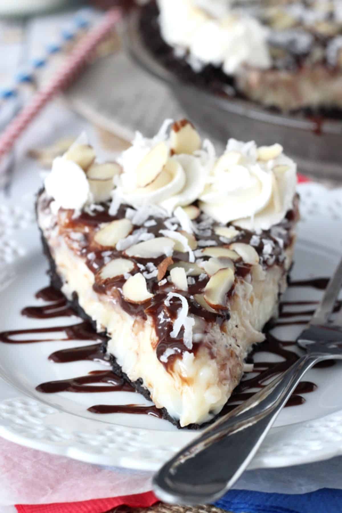 A slice of almond joy pie on a white plate.