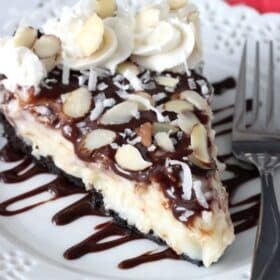 A slice of almond joy pie on a white plate.