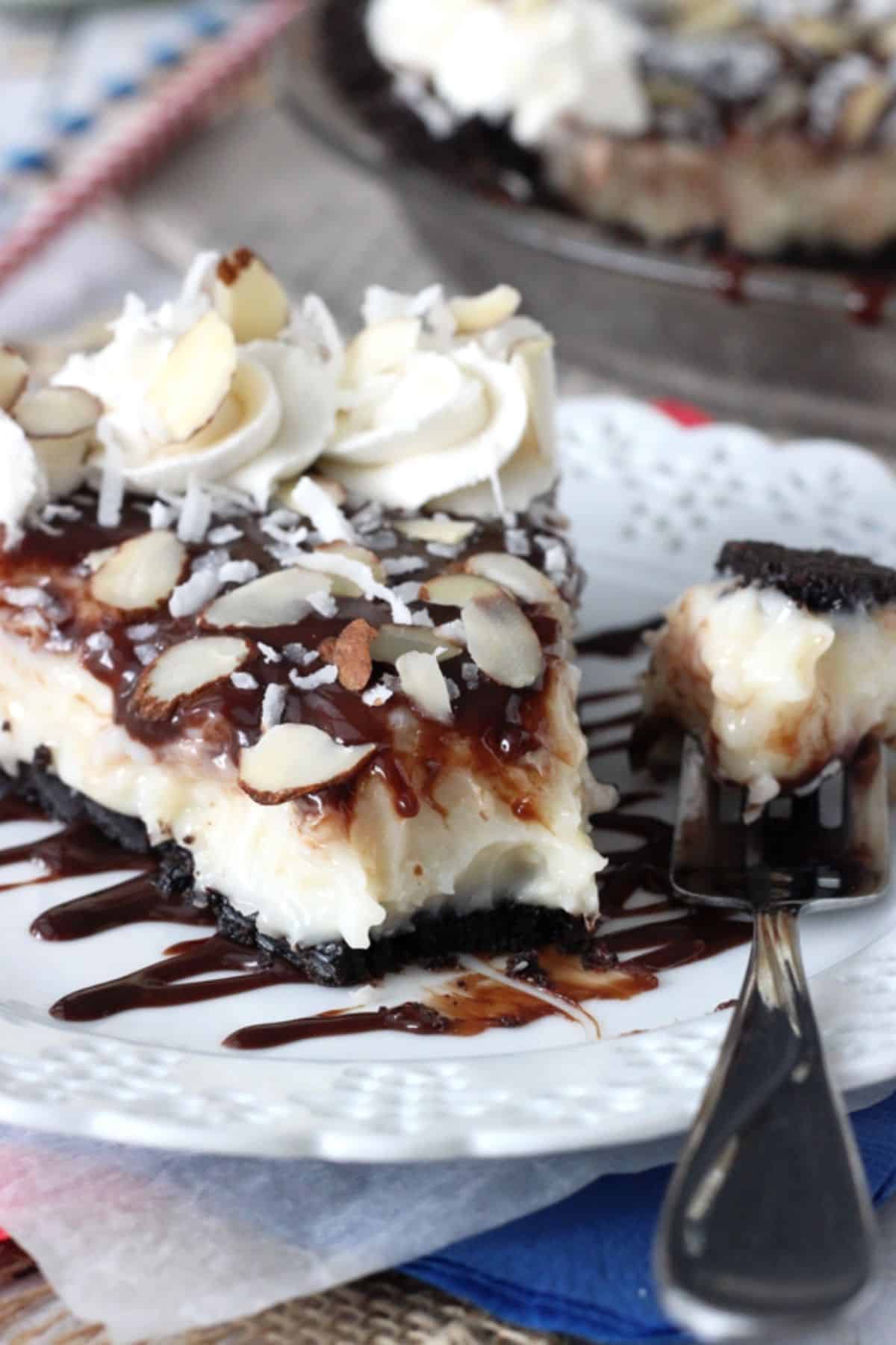 A slice of almond joy pie with a bite removed on a fork.
