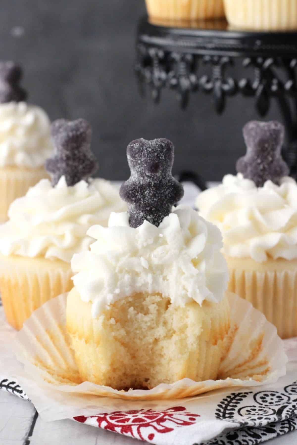 An anise cupcake with a bite taken out of it and the wrapper pulled down.