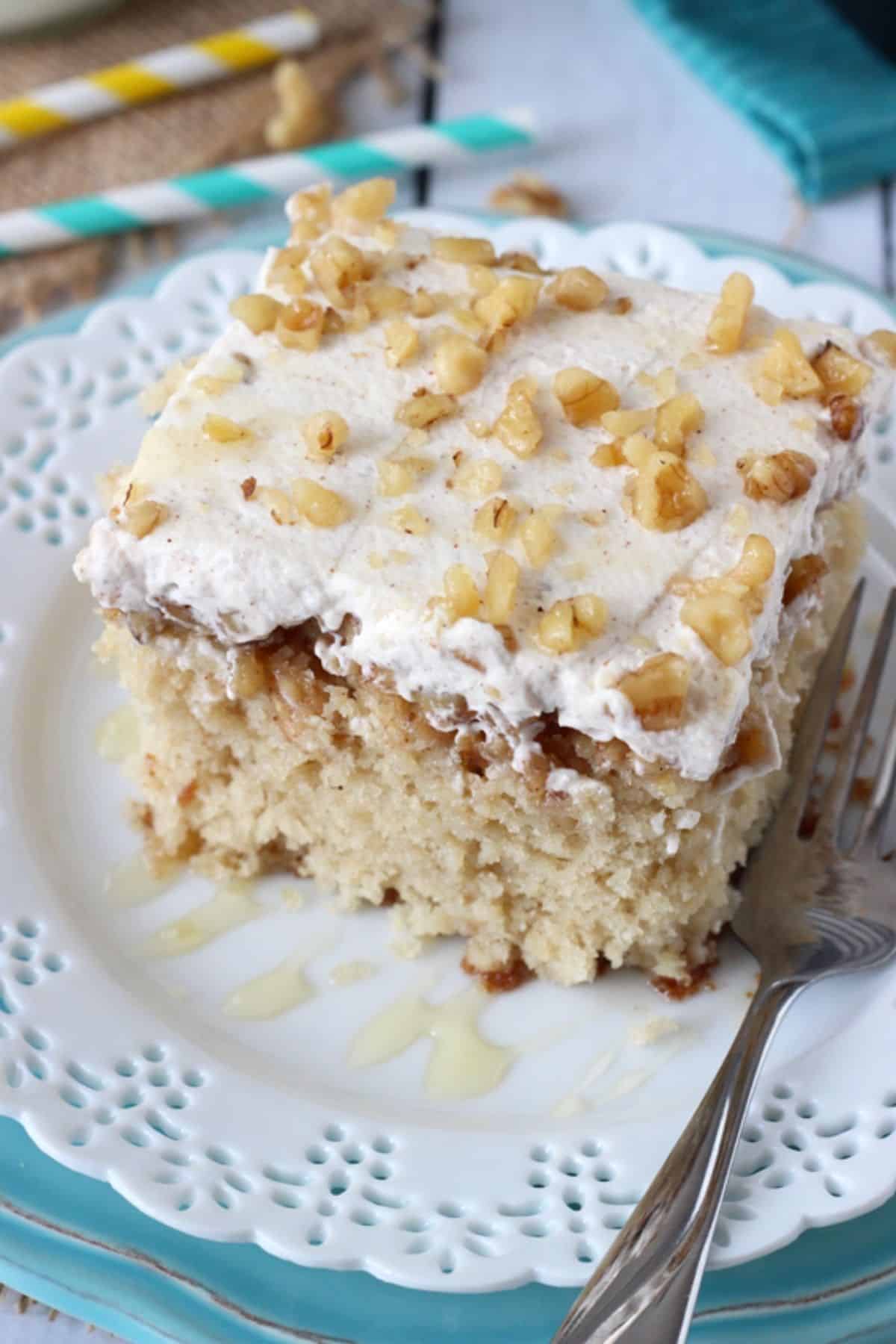 Top view of a slice of baklava poke cake on a white plate.