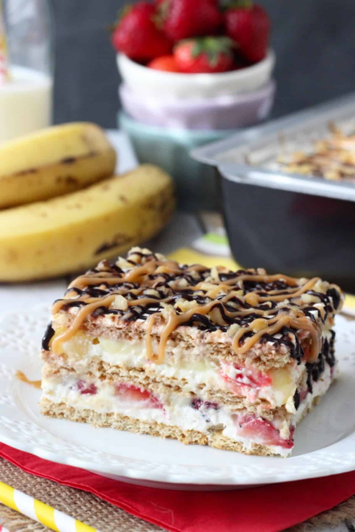 A slice of banana split cake on a white plate.