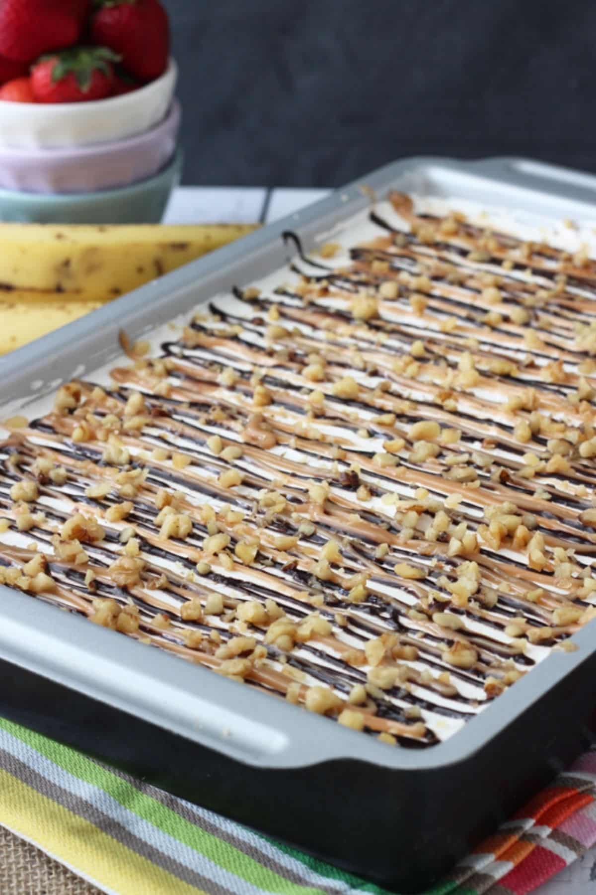 A banana split icebox cake in a metal baking pan.