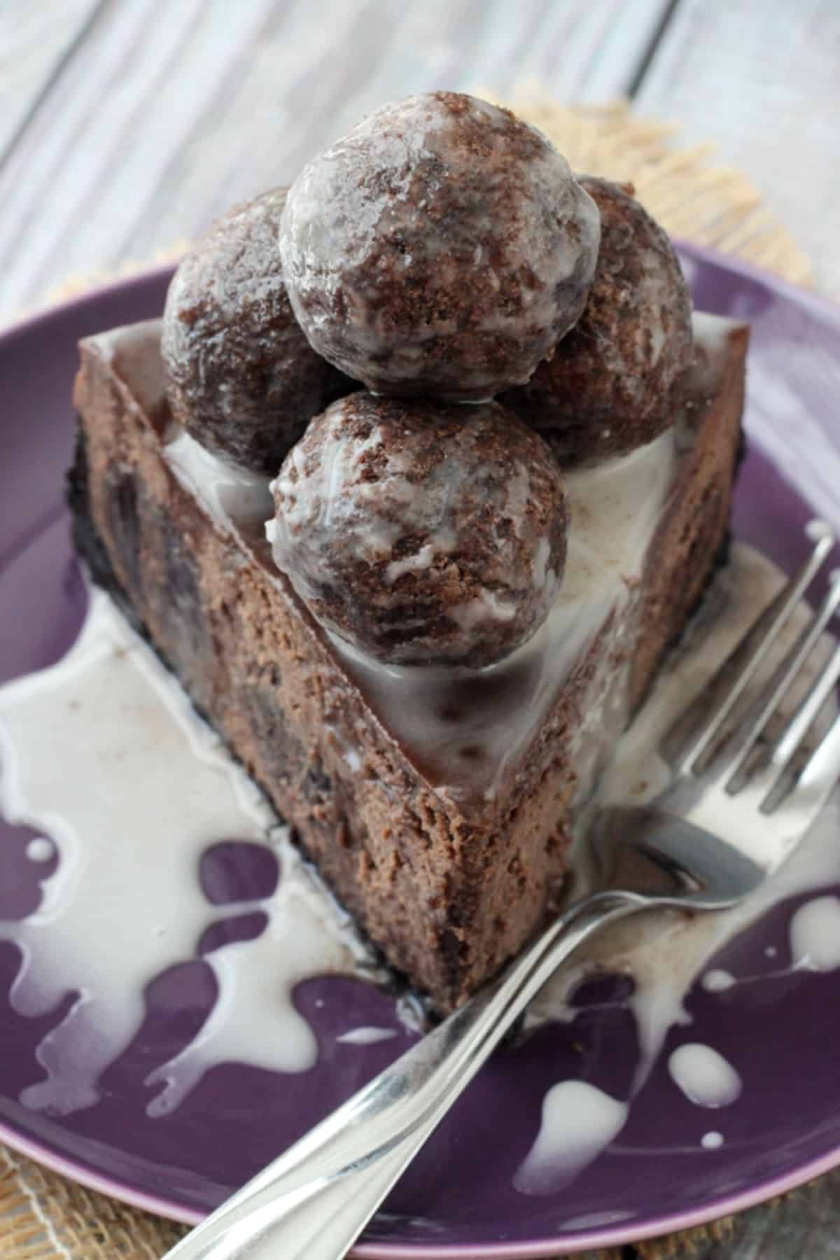Top view of a slice of chocolate donut hole cheesecake piled high with donut holes.