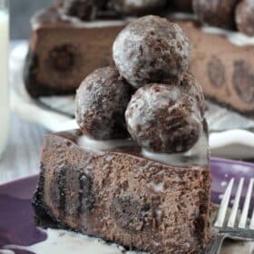 A slice of chocolate donut hole cheesecake piled high with donut holes.